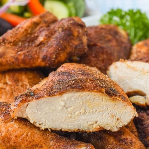 Copycat KFC Roast Chicken close up photo of a chicken breast sliced in half to show juicy interior