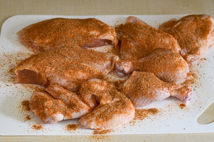 Copycat KFC Roast Chicken photo of uncooked chicken pieces sprinkled with seasoning mix