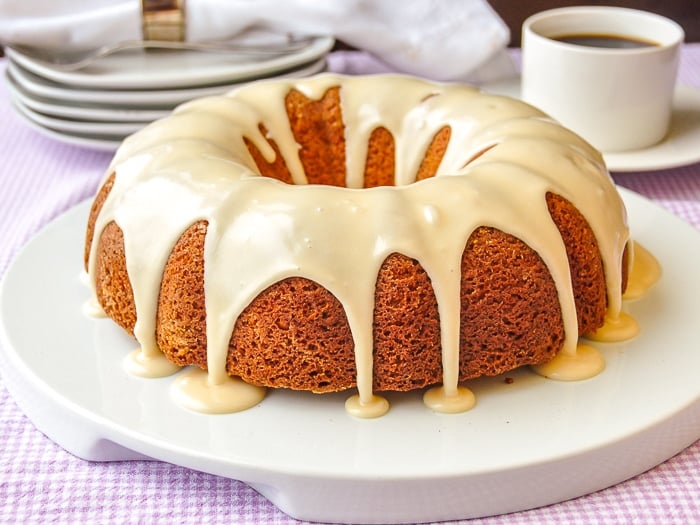 Maple Vanilla Bean Bundt Cake photo of uncut cake on with coffee service in the background