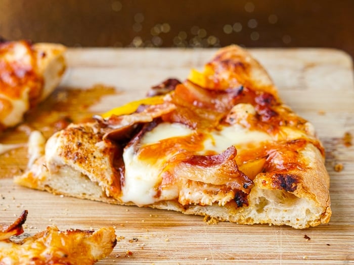 !lose up photo of a slice of BBQ Chicken pizza