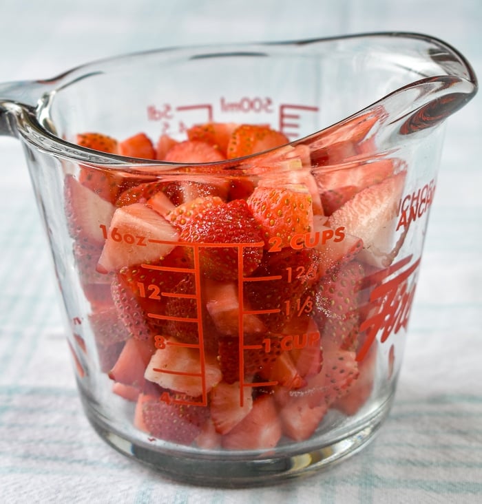 Diced strawberries in a clear glass measuring cup