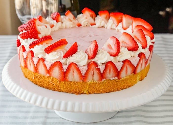 Strawberry Marshmallow Mousse Cake wide shot photo of entire finished cake on a white pedestal