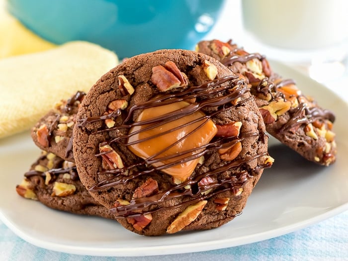 Wide shot photo of Turtle Cookies stacked on a white plate