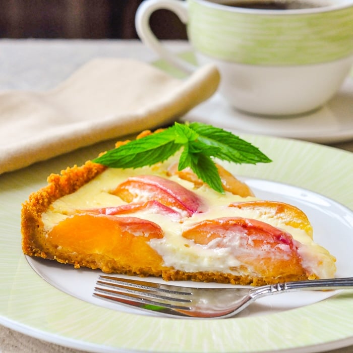 Summer Peach Custard Tart single slice on a green and white plate