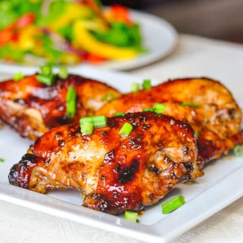 Honey Soy Chicken Breasts wider shot shown with salad in the background