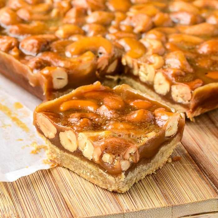 Close up photo of Honey Cashew Cookie Bars being cut on a wooden board