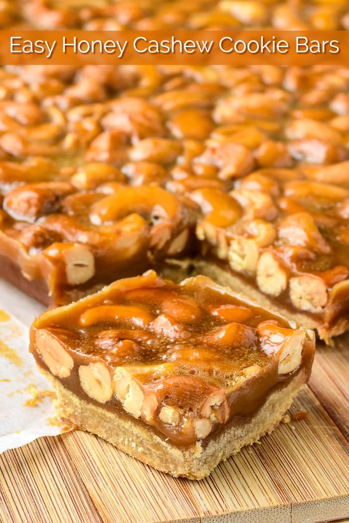 Honey Cashew Cookie Bars shown being cut on a wooden cutting board with title text added for Pinterest