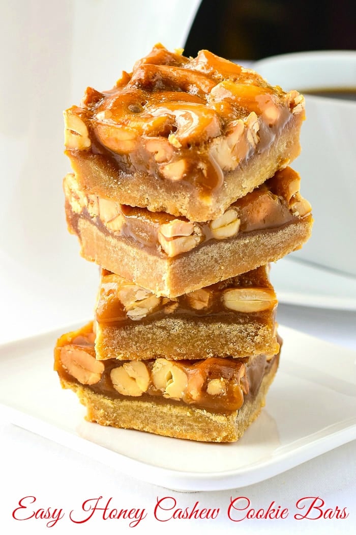Honey Cashew Cookie Bars stacked on a white plate with title text added for Pinterest