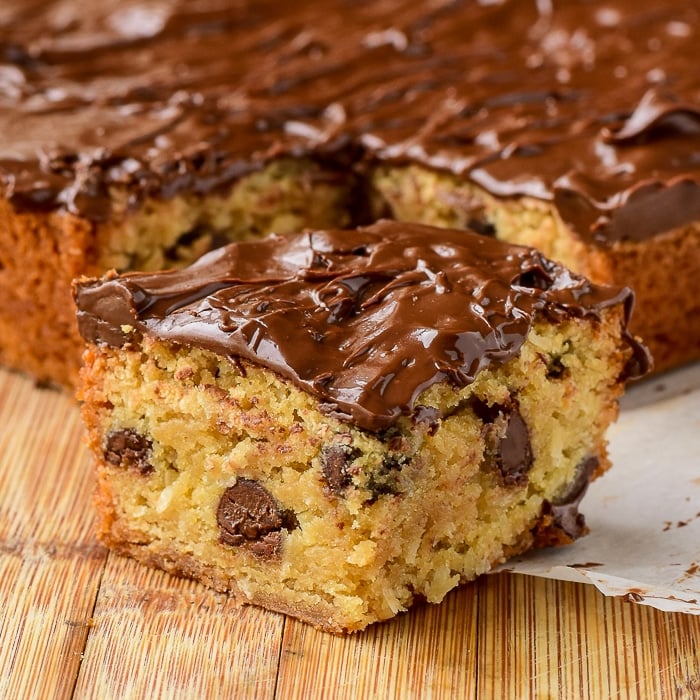 The Easiest Chocolate Chip Squares close up photo of one square cut on a wooden board