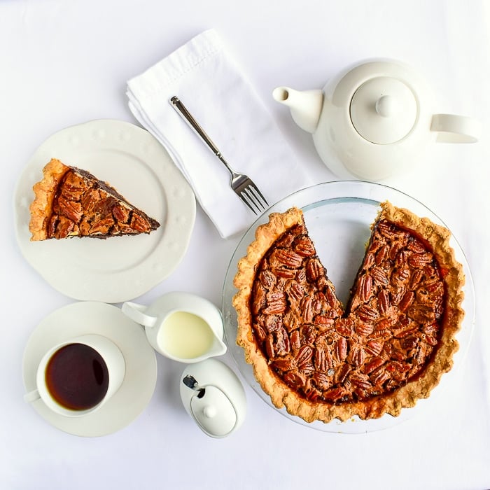 Over head photo of one slice cut out of the whole pie, surrounded by a white coffee service