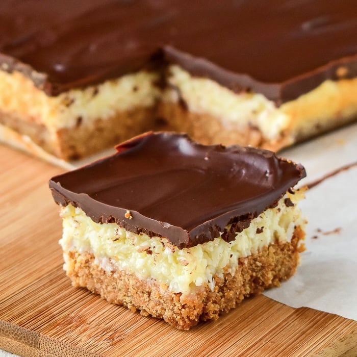 Coconut Dream Bars close up photo of one cookie on a wooden cutting board