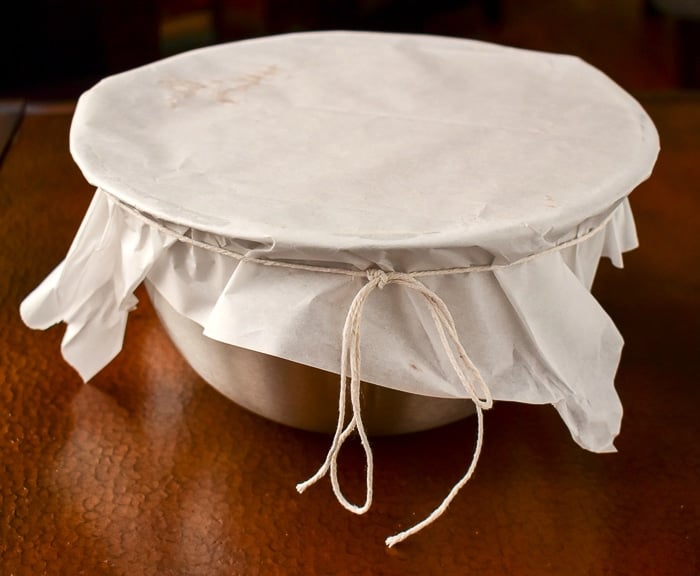 Cover the pudding bowl with a couple of layers of parchment paper and tie with butcher string