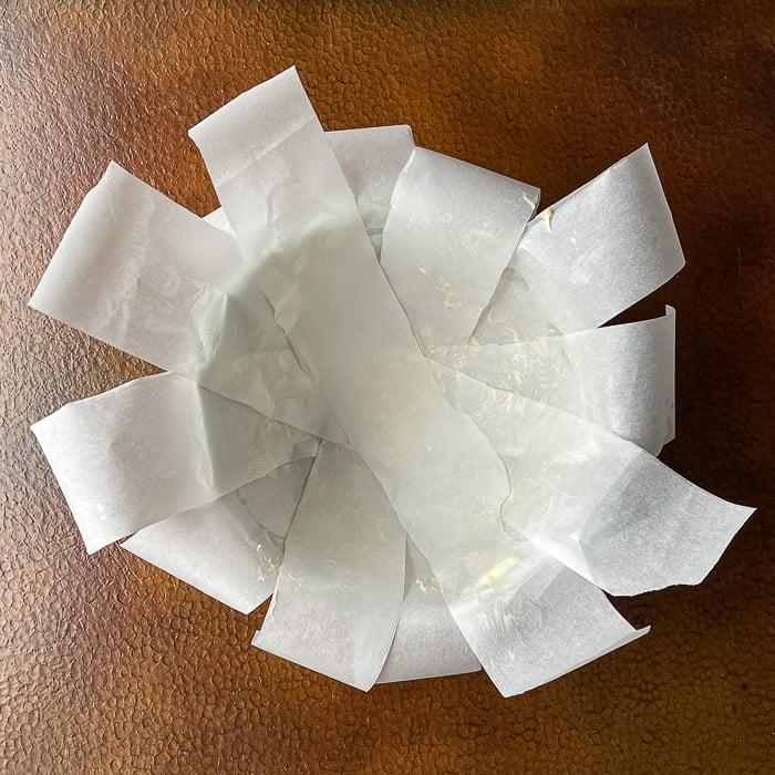 Lining the bowl with strips of parchment paper helps release the finished pudding