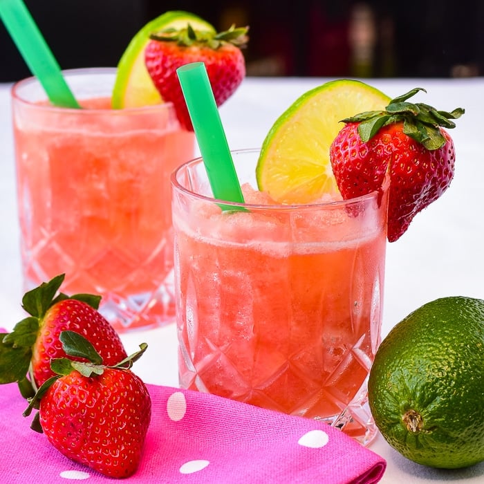 Photo of two Strawberry Lime Slush cocktails shown with pink polka dot napkin