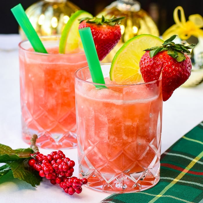 Strawberry Lime Slush photo of 2 cocktails with Cristmas decorations in background