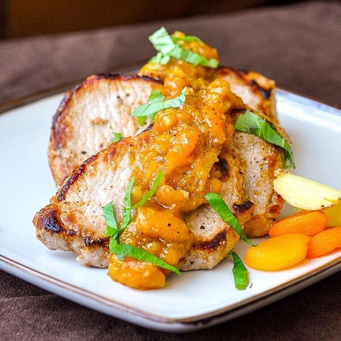 Apricot Ginger Chutney on Pan Seared Pork Chops shown on a square ceramic serving platter