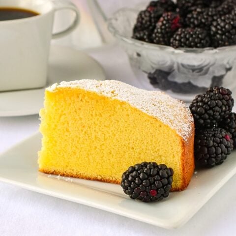 Close up photo of a single slice of condensed milk cake on a white plate