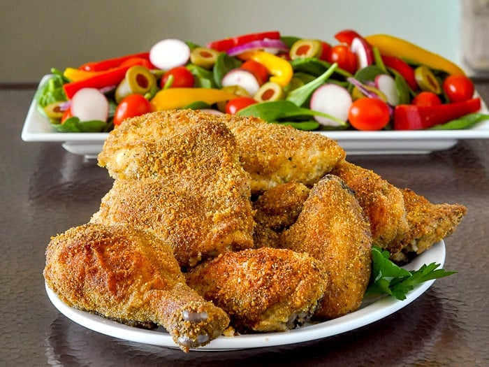 Copycat Italian Shake and Bake on a white platter with a salad in the background