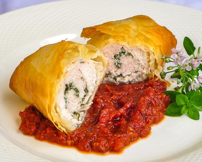 Phyllo Chicken Herb Roulade with Roasted Tomato Jam on a white serving plate