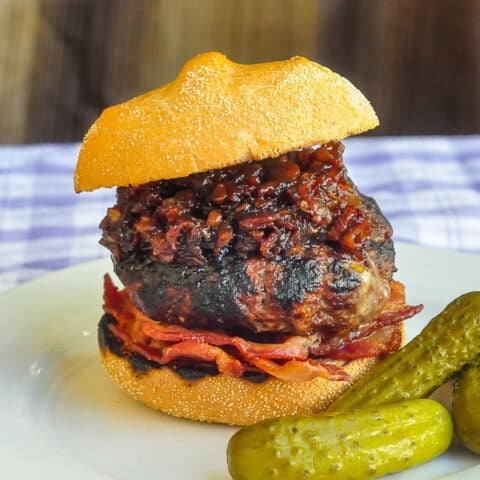 White Cheddar Burgers with beer and bacon jam photo on a white plate with pickles