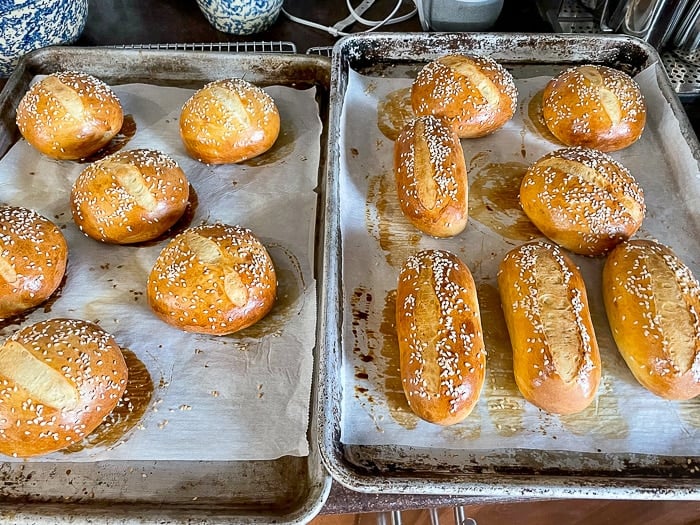 How to make the best hamburger buns recipe photo showing a completed batch of buns out of the oven that have been scored with a razor blade