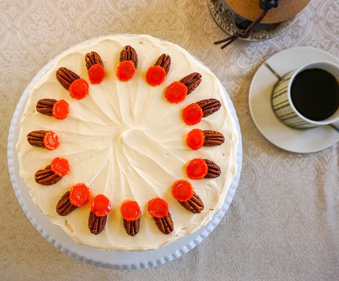 Overhead shot of an uncut carrot cake with coffee