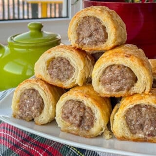 Italian Sausage Rolls in Parmesan Pastry stacked on a white plate