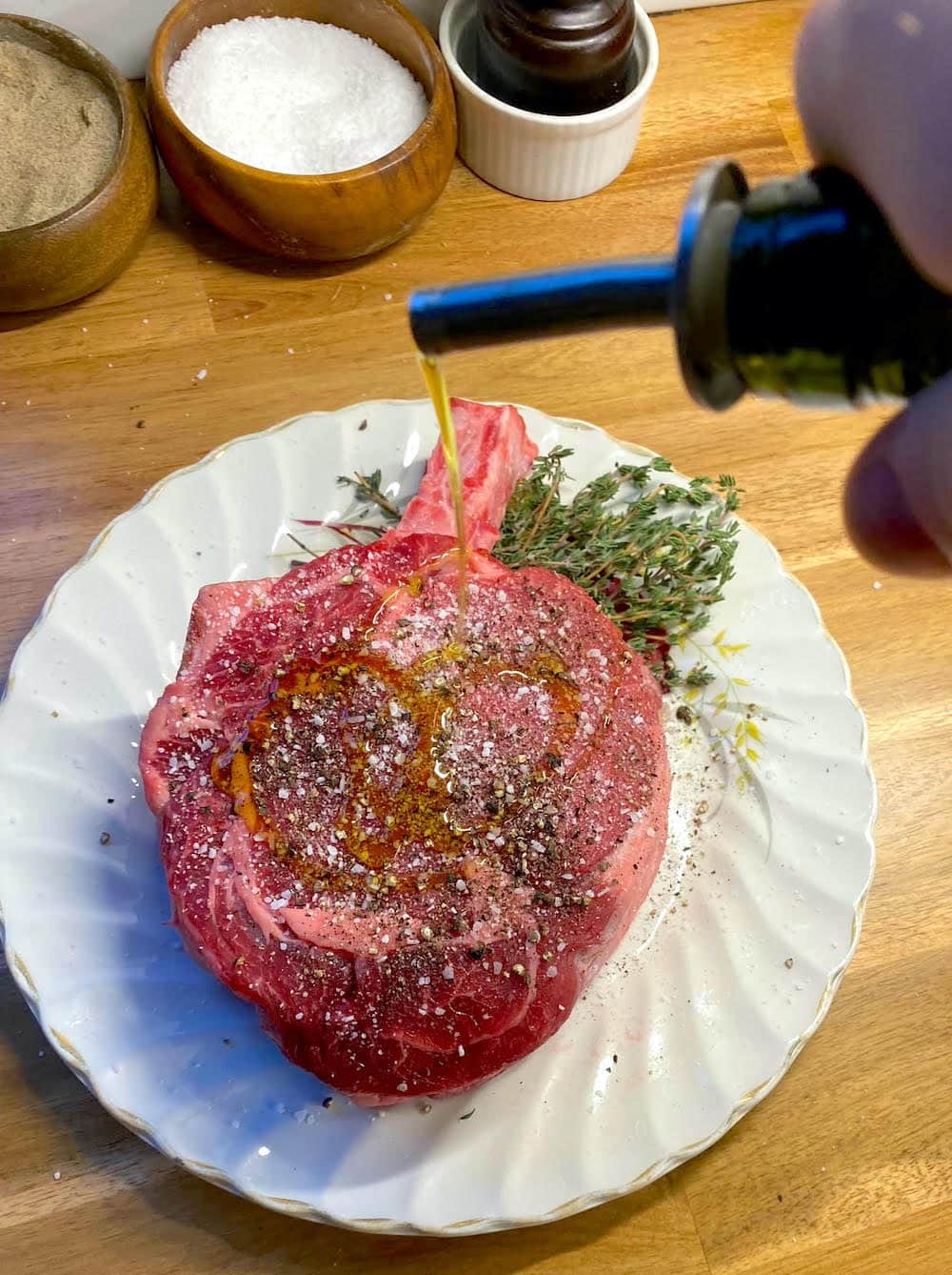 Adding seasoning and olive oil to the steak