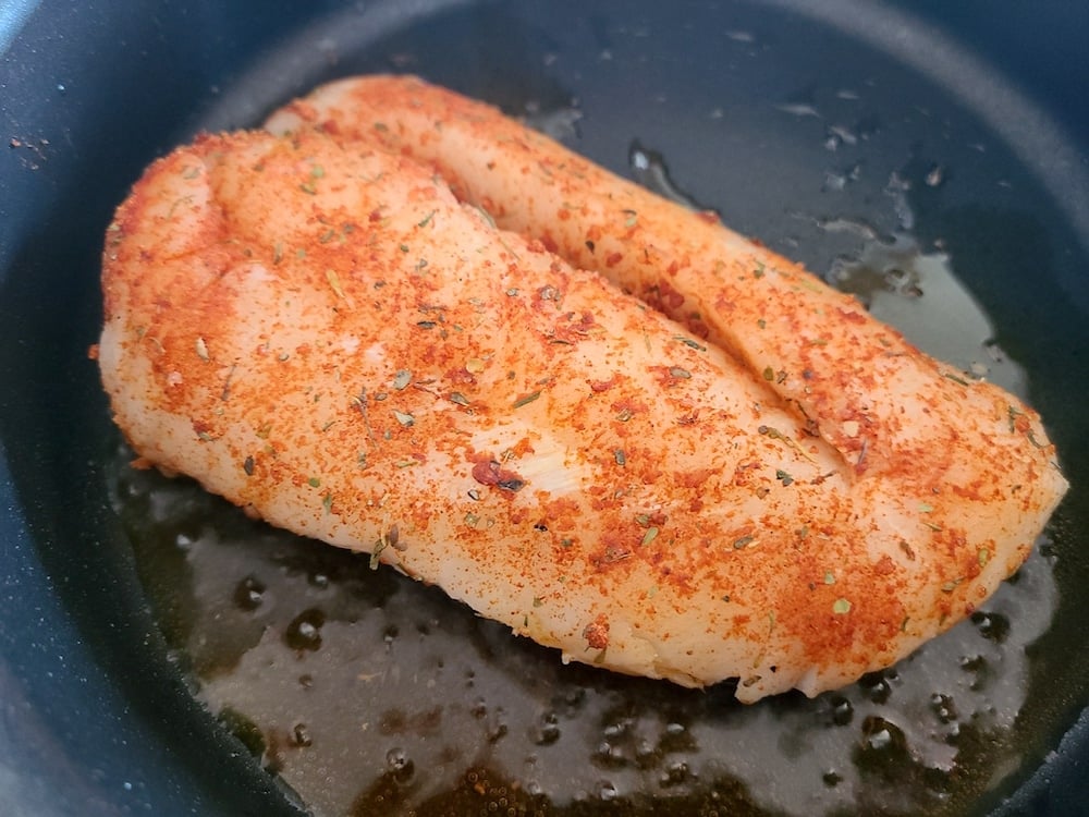 Adding the cod fillets to the pan