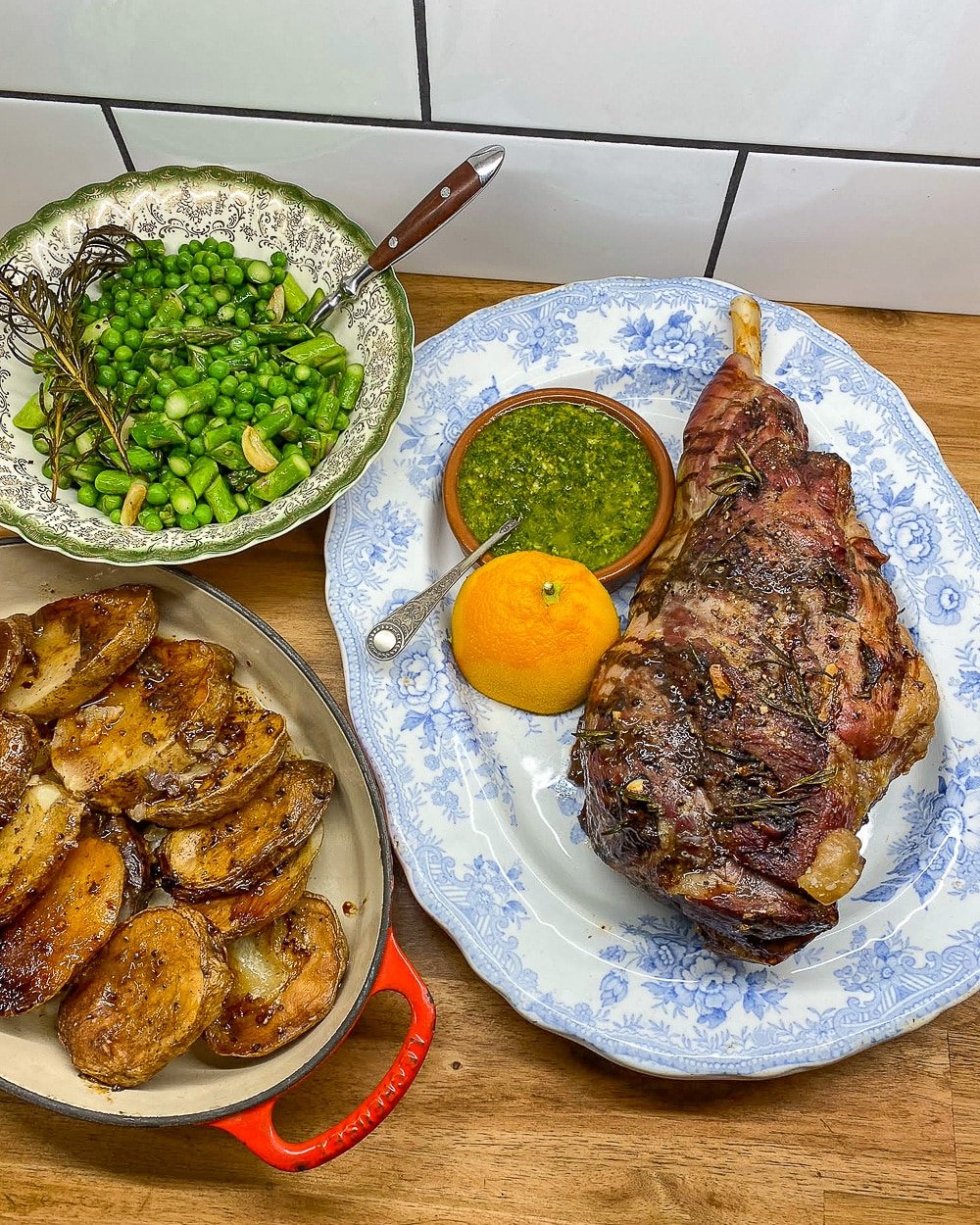 Roast leg of lamb with potatoes, mint gremolata and garlic peas and asparagus