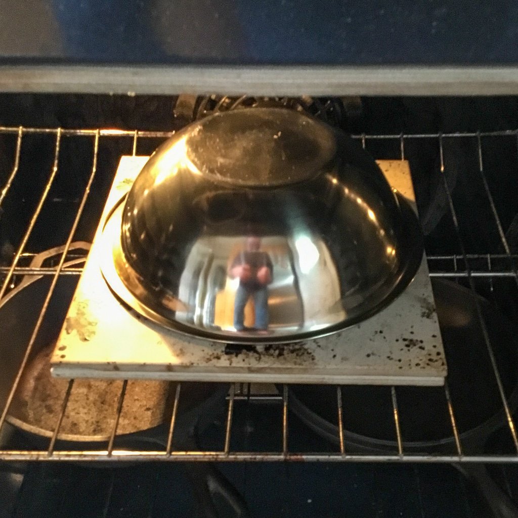 Dough in oven with bowl covering.