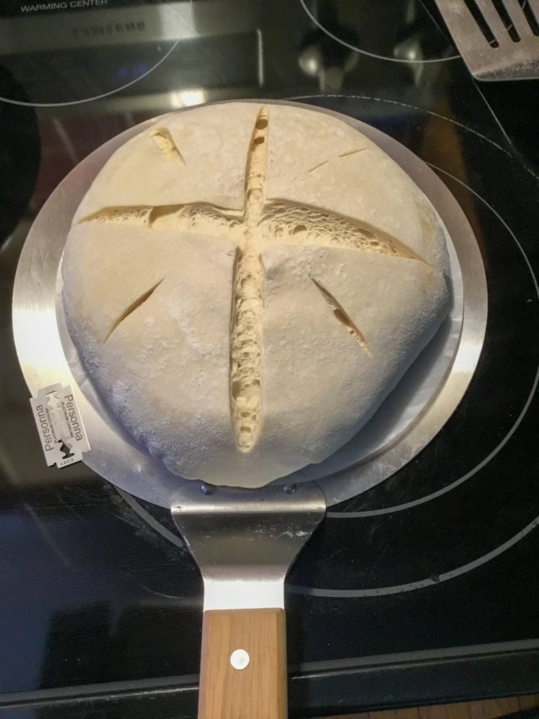 A boule of dough slashed with a razor blade