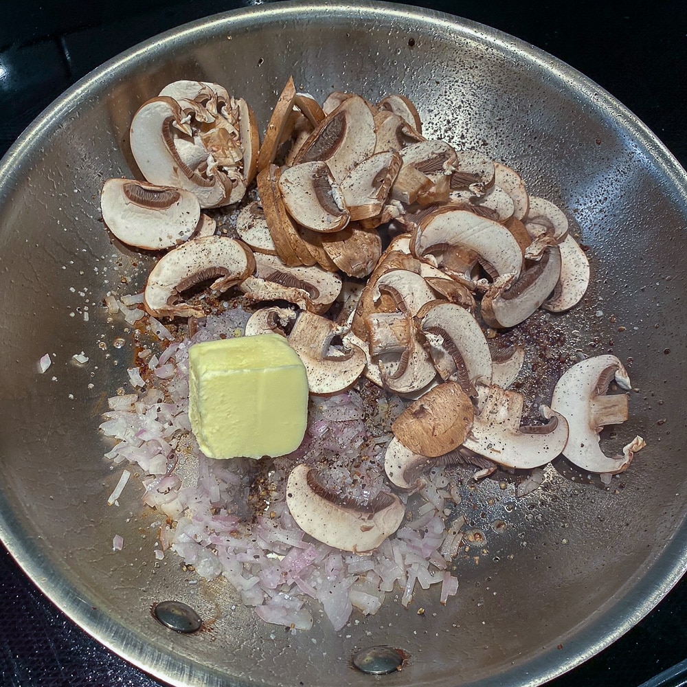 Adding mushrooms and butter to the pan