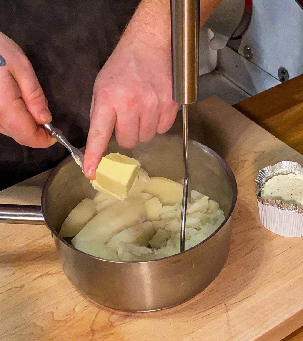 Adding the butter to the mashed potatoes