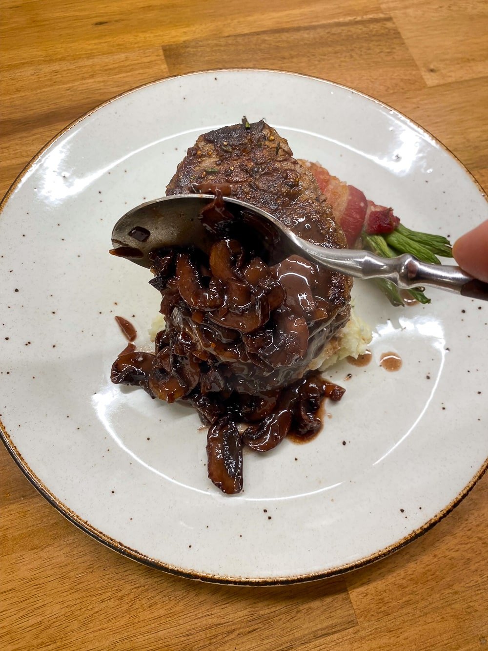 Adding the mushroom sauce to the plate