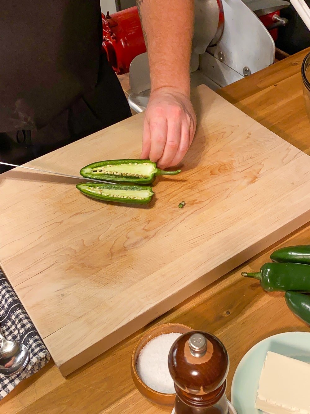 Cutting the jalapenos in half.