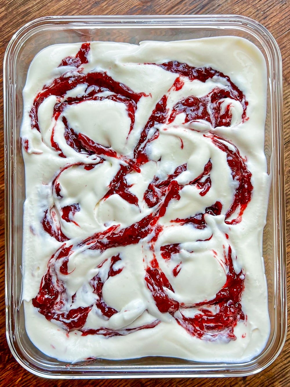 Swirling the jam through No Churn Strawberry Vanilla Ice Cream