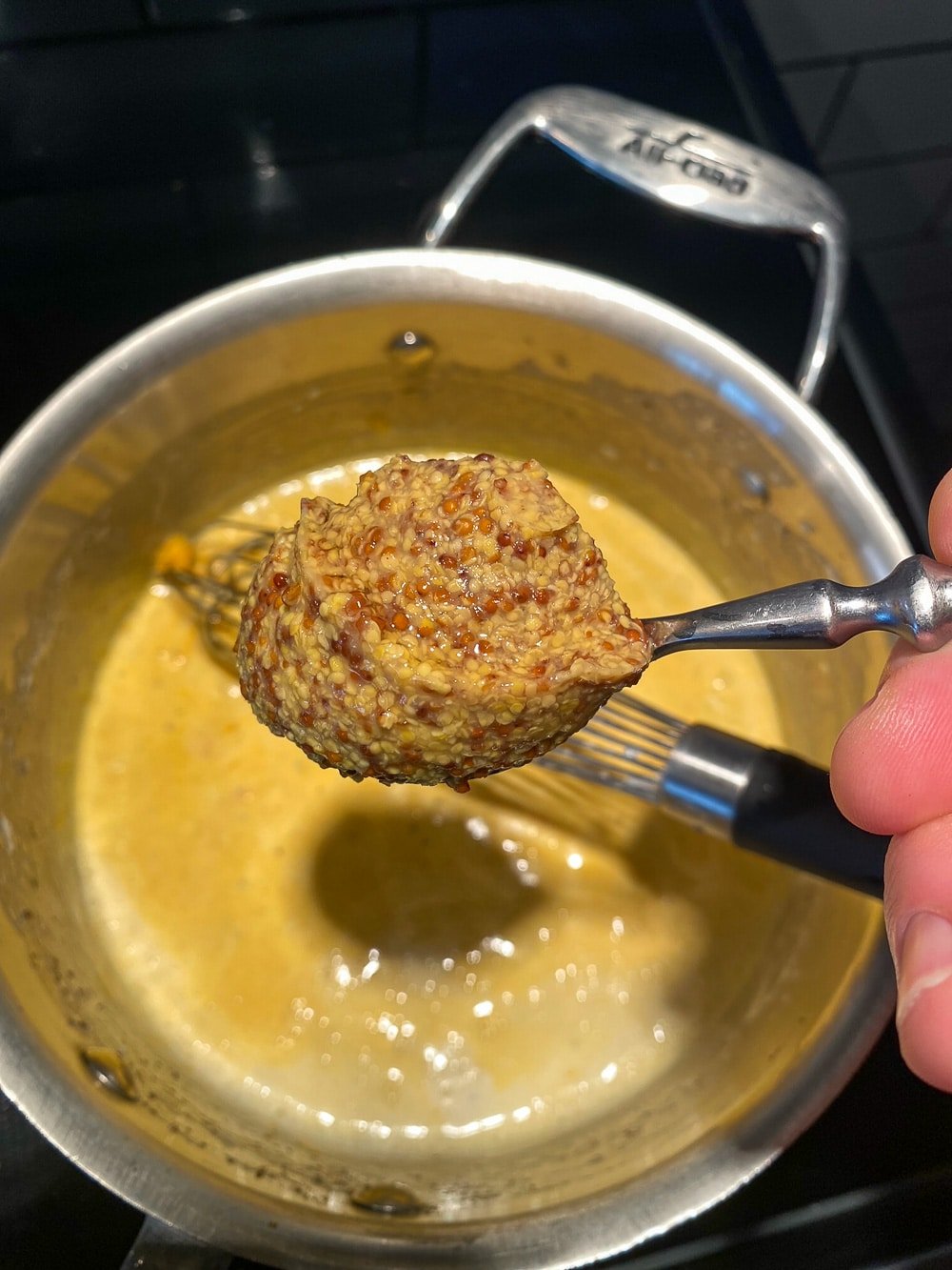 Adding the mustard to the sauce