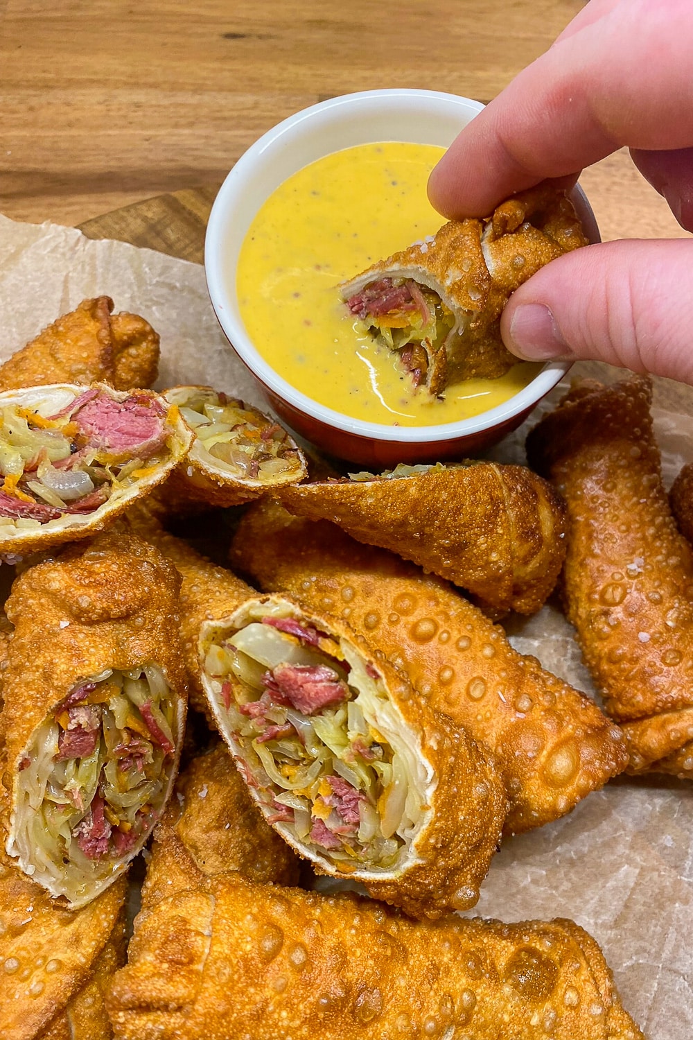 Dipping the Corned Beef & Cabbage Egg Rolls into the sauce