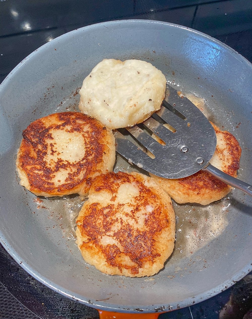 Turning Irish Potato Cakes boxty in a frying pan.