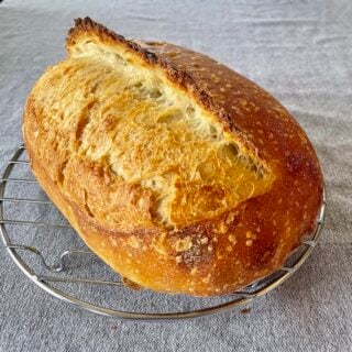 How to make Artisan Sourdough Bread photo of a baked loaf.