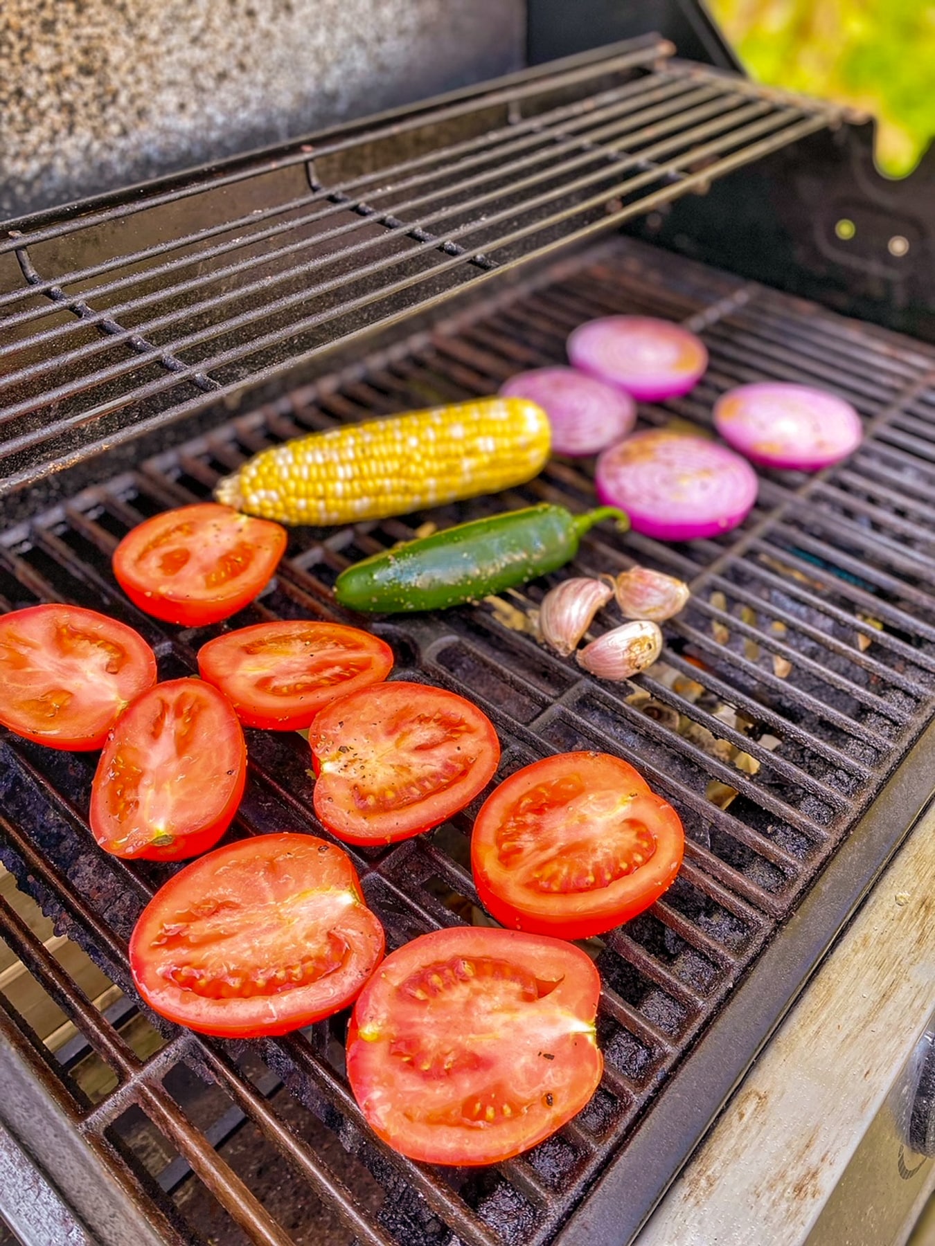 Ingredients for salsa placed on a hot grill.