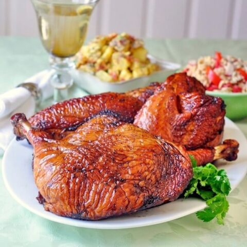 Simple Brined Smoked Turkey close up featured photo of finished turkey with side dishes in the background.