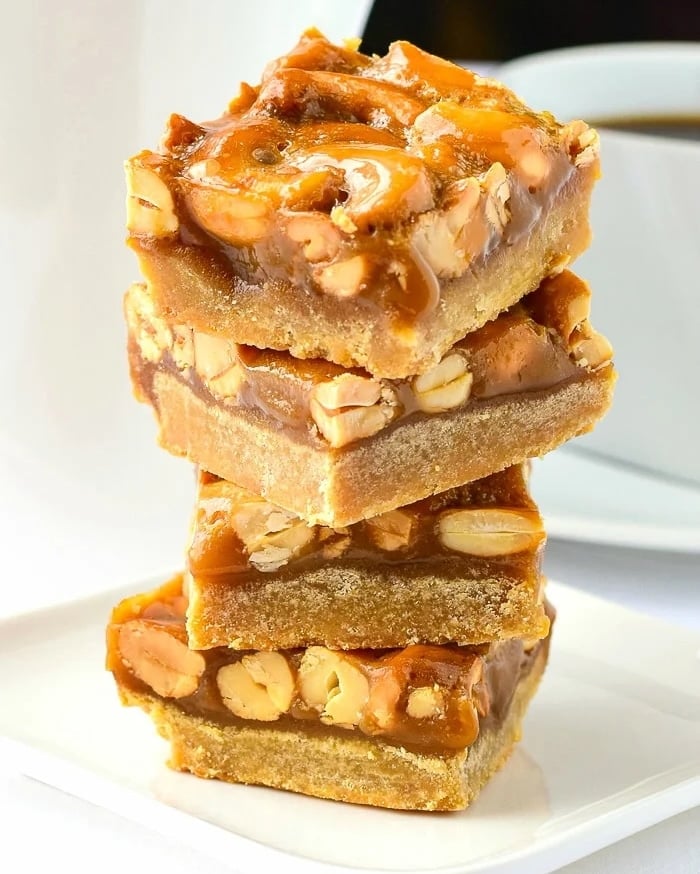 Honey Cashew Cookie Bars stacked on a white plate, photo for Facebook and Instagram.