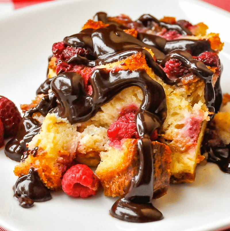 Raspberry Chocolate Bread Pudding square cropped featured image of a single serving on a white plate for Google featured image.