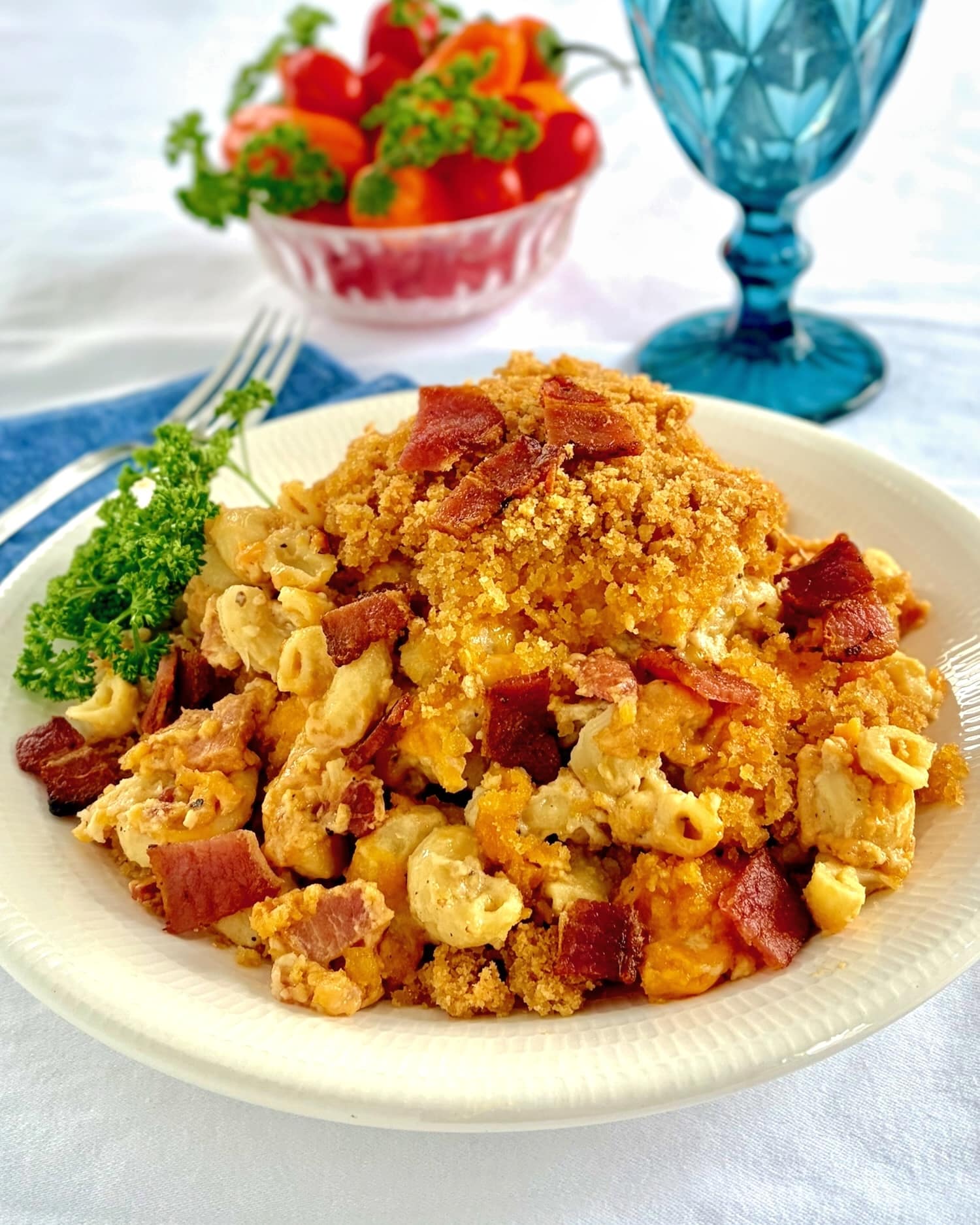 Bacon Macaroni and Cheese.photo of one serving with tomatoes in the background.