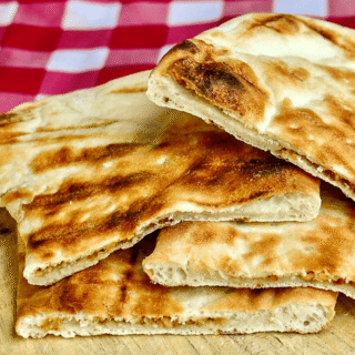 Coconut Cashew Raisin Naan photo of cooked naans on a wooden cutting board