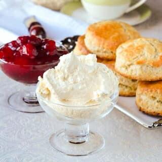 Homemade Clotted Cream in a clear glass footed bowl.