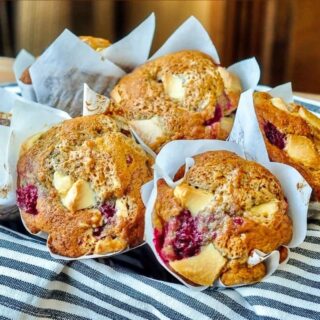 Banana Raspberry White Chocolate Muffins in a baket, square cropped for Google featured image.