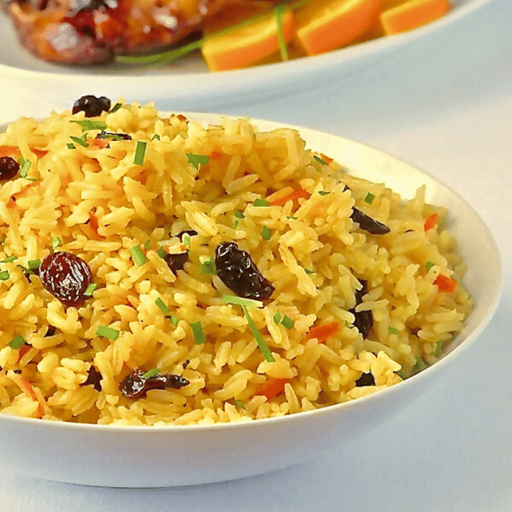 Featured image. carrot Raisin Rice Pilaf in a white serving bowl